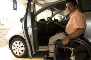 Disabled man in wheelchair next to handicap van