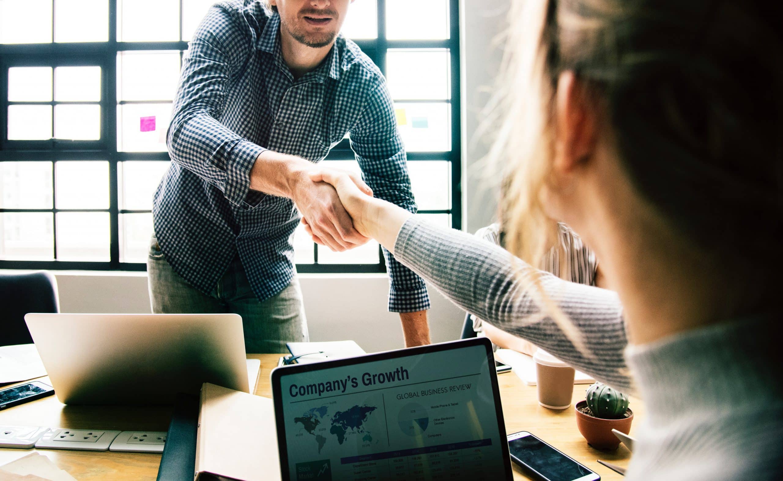 Man shaking hands with woman in professional office setting