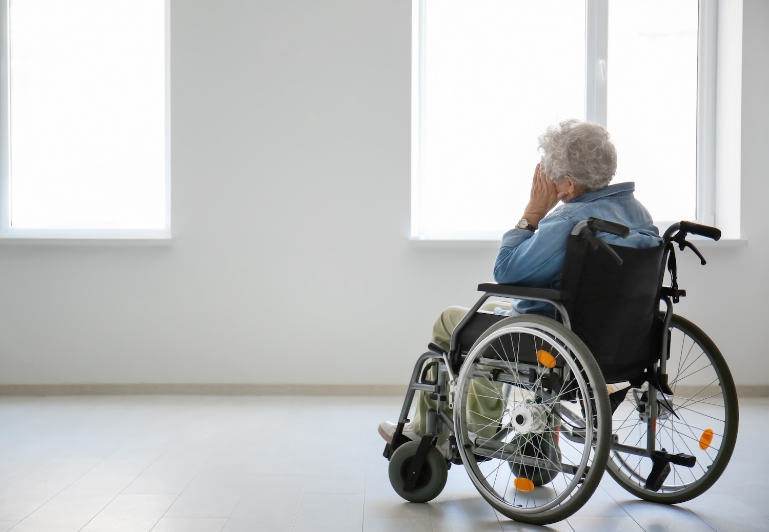 Older woman in wheelchair wearing denim short